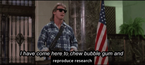 Nada (Roddy Piper) in John Carpenter’s They Live, standing in the bank lobby holding a shotgun and wearing sunglasses. The caption reads “I have come here to chew bubblegum and reproduce research.”