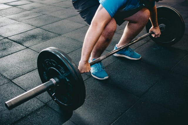 A man lifting a barbell with weights.