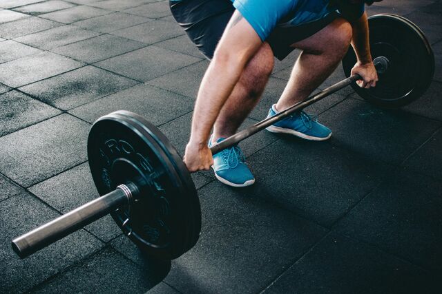 A man lifting a barbell with weights.