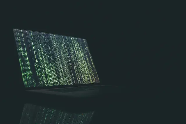 A laptop showing a Matrix-like green display.